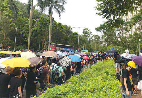 8月4日下午15時15分,由於遊行人士太多,已逼出寶豐路馬路,有駛經的巴士調頭讓路給遊行隊伍。(林怡/大紀元)