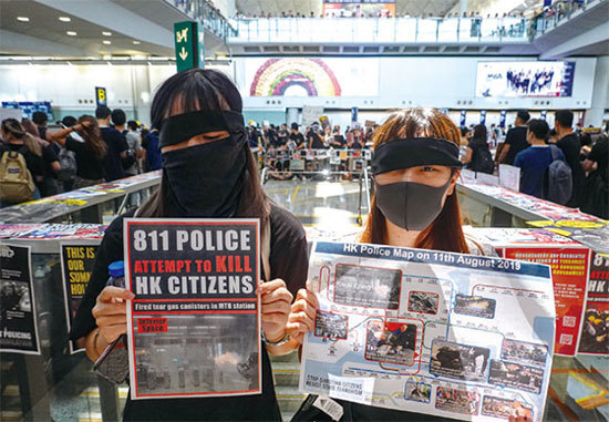 8月12日，響應「百萬人塞爆機場」集會的示威民眾，持中英文展板、標語譴責警察暴力。（余鋼／大紀元）