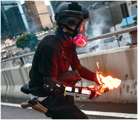 8月31日,一名示威者打扮的男子正準備投擲一枚汽油彈,但腰部露出疑似港警使用的手槍,被質疑警方自導自演。(AFP)