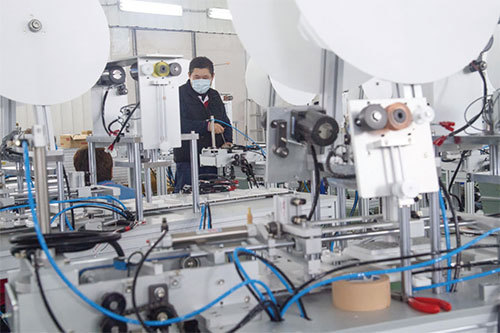 疫情爆發後，臺灣立即建立新的口罩生產線，更調派國軍來提高口罩產量。（中央社）