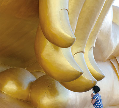 大劫難結束後,可能還有20年左右的「過渡期」,以恢復傳統、道德和正信。圖為2020年7月2日一名婦女在泰國最大坐佛的指尖下祈禱。(AFP)