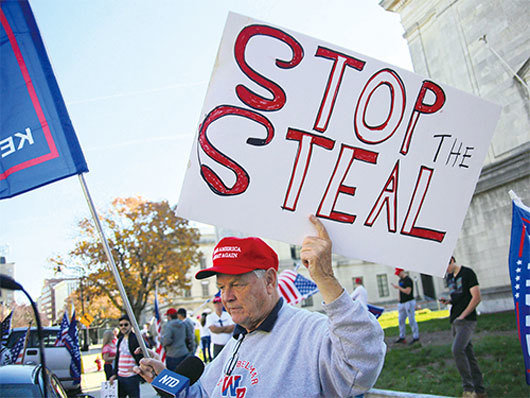 弗林將軍說，美國人正在挺身而出，將他們知道的真相講出來。圖為2020年11月7日，參與「制止偷竊」集會的新州居民，手舉「制止偷竊」（Stop The Steal）看板接受採訪。（黃小堂／大紀元）