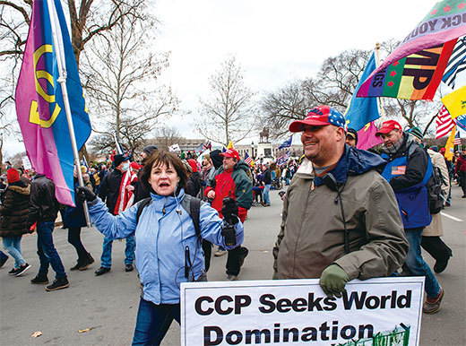 1月6日前往華府國會山莊參加「制止竊選」集會的特朗普支持者舉著牌子,指責中國共產黨尋求「世界統治」的野心。(Joseph Prezioso / AFP)