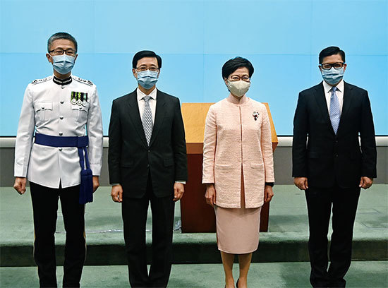 國安法生效一周年前夕,中共在香港建「警察政府」。6月25日港府人事大變動,李家超(左二)成為政務司長,鄧炳強(右一)為保安局長。原政務司長張建宗被免職。(宋碧龍/大紀元)