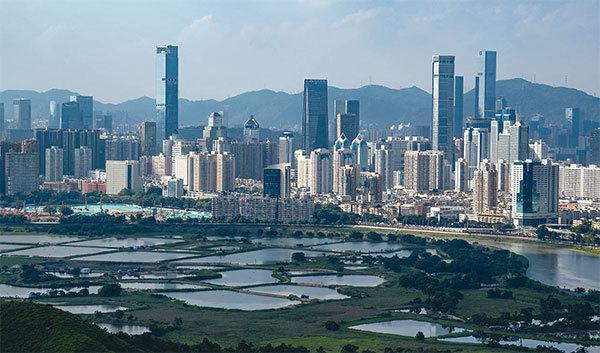 廣東維穩經費反常地大幅度超過新疆。香港人早有懷疑,中共將廣東作為維穩香港的基地。圖為廣東省深圳市住宅樓和香港農田。(Bertha Wang / AFP)