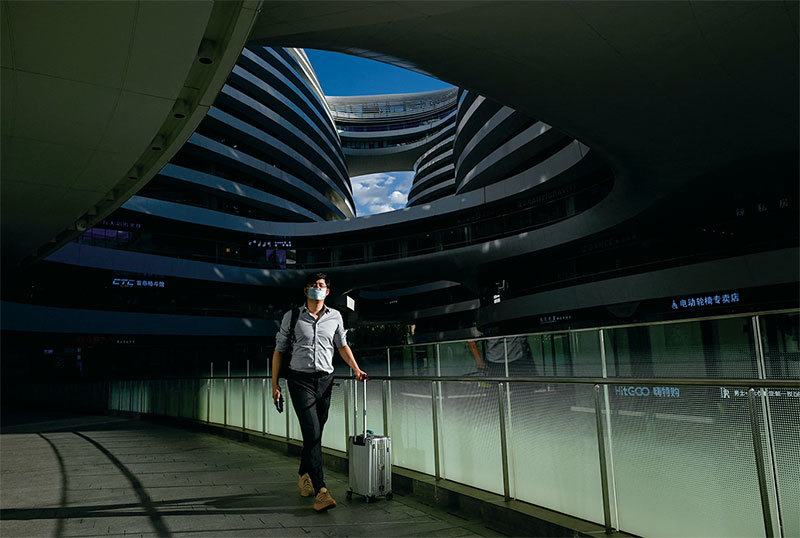 封哥找到一個高幹子弟合作,在北京一家部隊機關租了一層大樓。整棟大樓就是一個黑幕掩蓋下的鬼樓,並不掙錢營利,但只要有銀行在,這些依附權貴的公司就不會倒。圖為2022年8月15日,北京一座綜合大樓。(Wang Zhao / AFP)