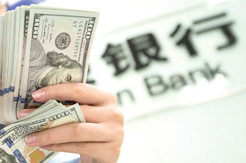 封哥的老闆向銀行貸款,款到手以後企業就宣布倒閉。而那個負責銀行信貸的主管其實就是個内鬼。圖為中國一家銀行內,行員正在點鈔。(STR / AFP)