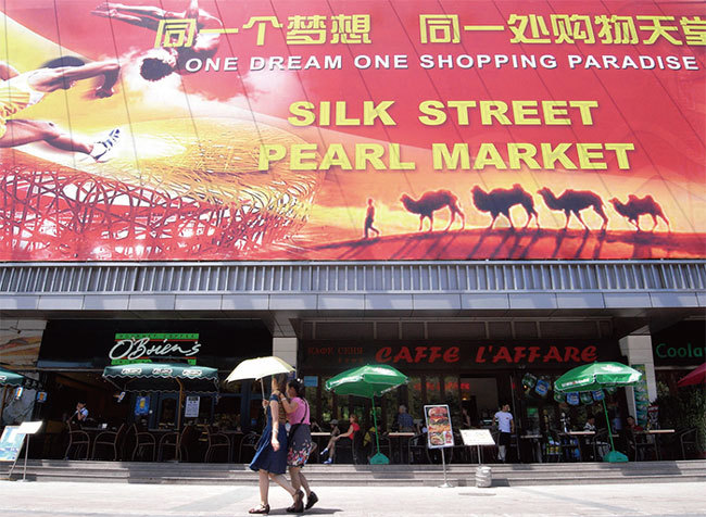 自克林頓時期，美國開始擴大與中共的經貿合作，並與人權問題脫鉤，美國遭遇中共知識產權盜竊，貿易逆差與日俱增。圖為北京秀水街著名假貨市場。（AFP）