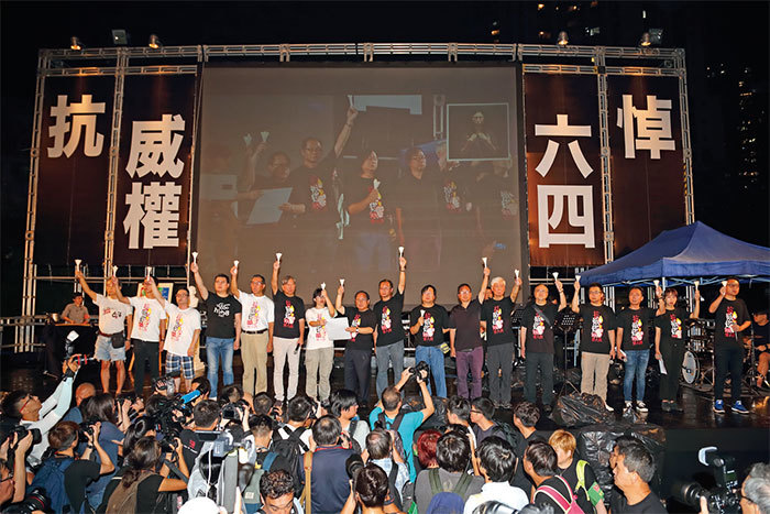 支聯會主席何俊仁及數名年輕人,到臺上燃點象徵民主的火炬,臺下已一片燭海。(蔡雯文/大紀元)