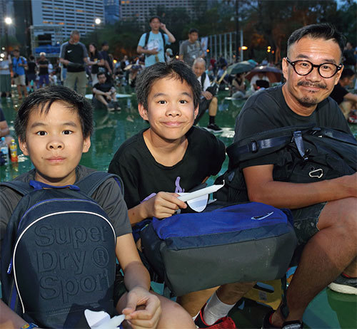 市民李先生在他兩個小孩五、六歲時就帶他們參加集會。(李逸/大紀元)