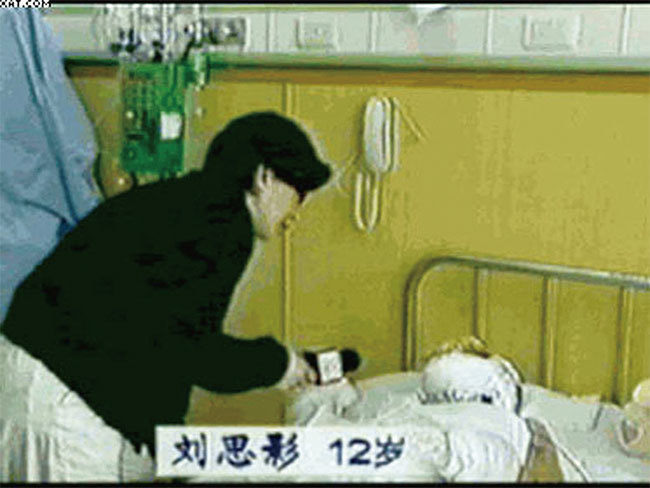 根據醫學常識,為防細菌感染危及生命,大面積燒傷病人要住隔離病房,探視者需穿戴隔離衣帽,而官方記者直接穿便服近距離採訪劉思影,分明是在演戲。(資料圖片)