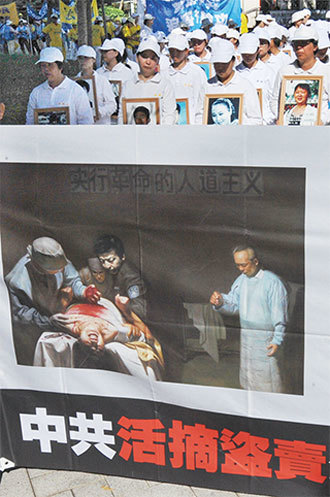 翻牆出去後,看到中共活摘器官時,完全不敢相信,是人怎麼可能這麼殘忍?圖為2014年7月20日臺北一遊行活動中揭露中共活摘法輪功學員器官。(AFP)