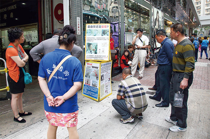 我體悟被共同業力的鏈綁縛的人,不退出邪黨,怎能避免墮入惡道的命運?圖為香港的大陸遊客在旅遊景點了解法輪功真相和進行三退。(攝影/潘在殊)