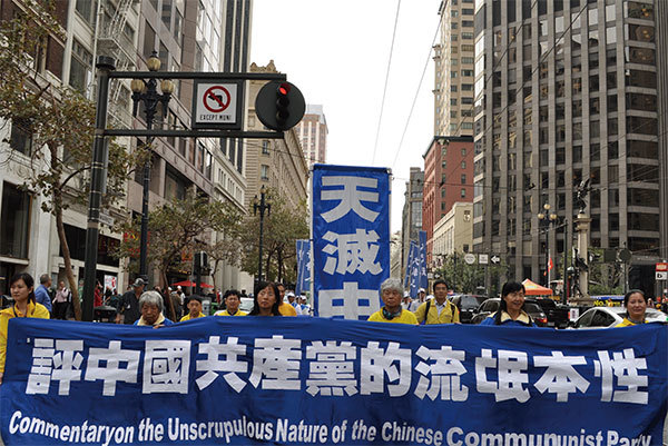 中共「劫持人質」的作法,已向國際社會展示其流氓本質。圖為2014年10月15日法輪功學員舊金山市中心遊行隊伍中的橫幅之一:《九評共產黨》〈【九評之九】評中國共產黨的流氓本性〉。(大紀元)