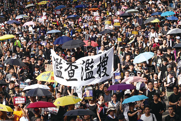 2019年7月21日，香港，民陣發起的反送中遊行隊伍中，有市民舉起橫幅抗議警方「濫查濫搜」。（余鋼／大紀元）